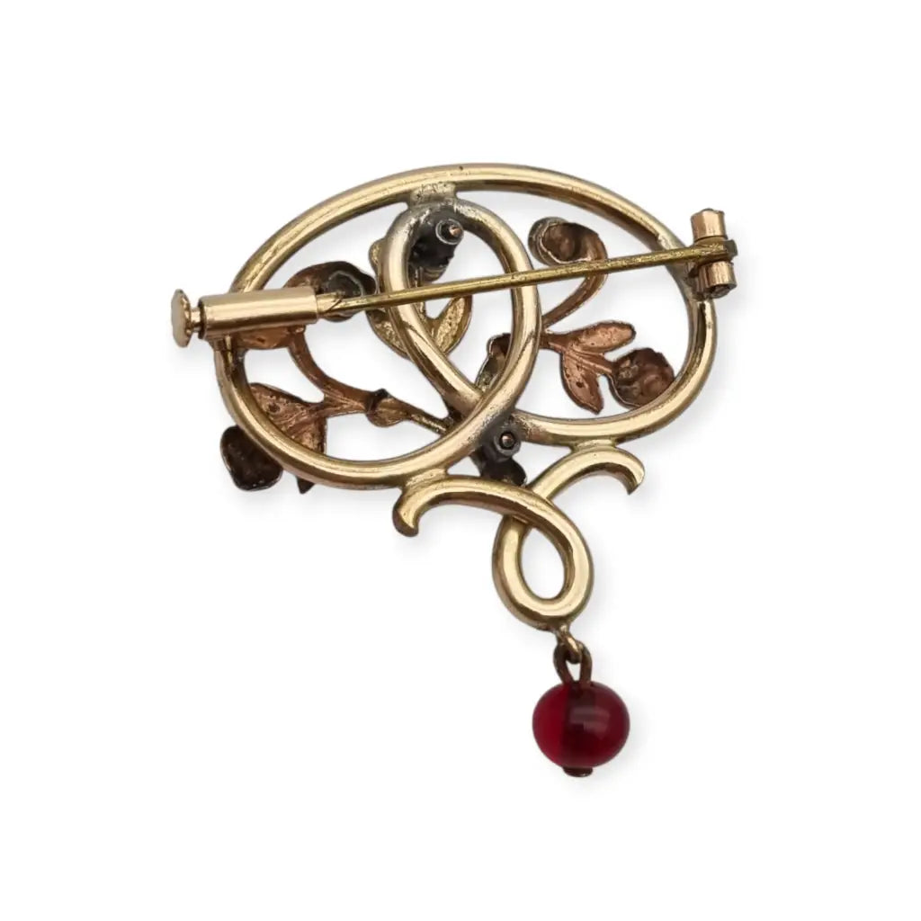 Broche Art Nouveau dorado con flor calada perlas y granates Circa 1900.