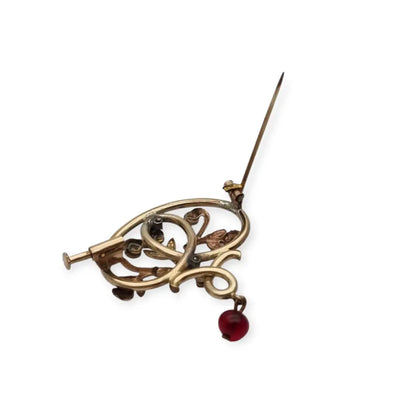 Broche Art Nouveau dorado con flor calada perlas y granates Circa 1900.