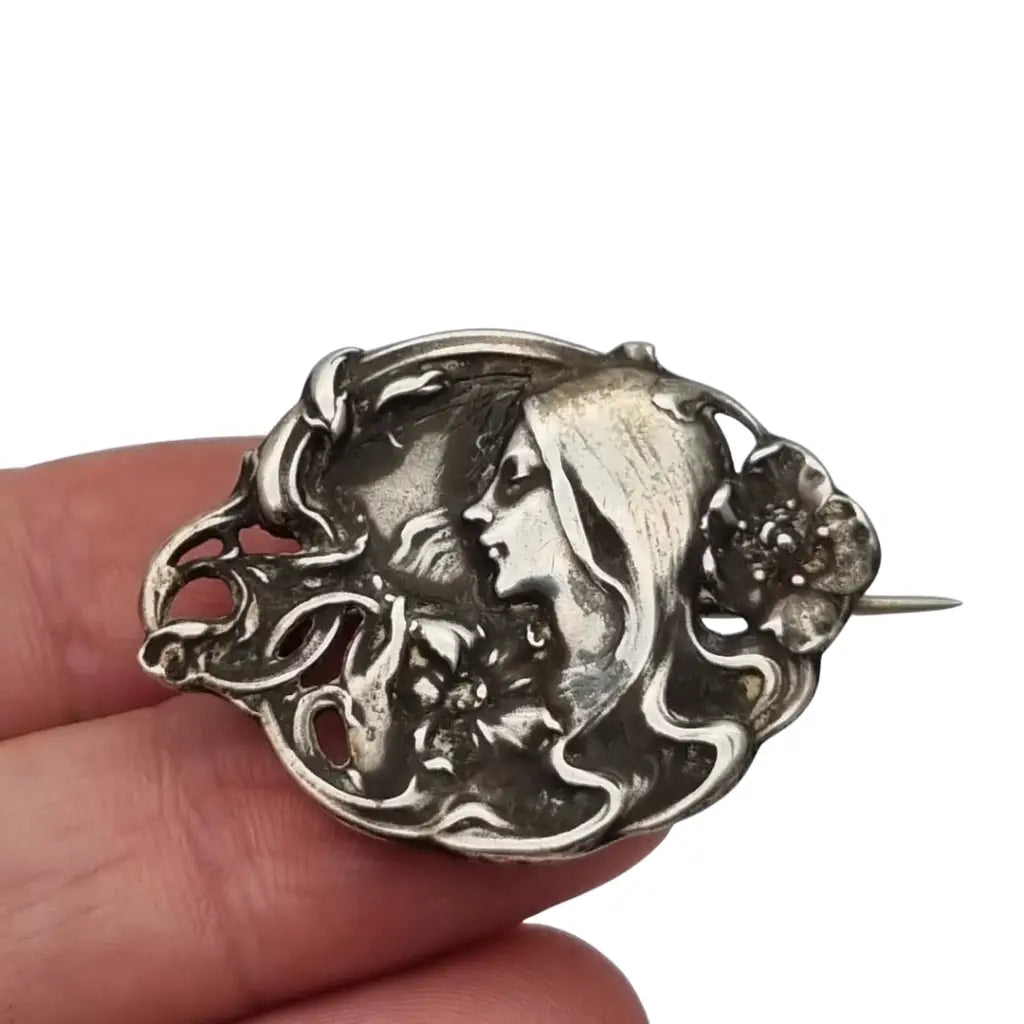 Broche Art Nouveau con mujer y flores en relieve diseño de líneas sinuosas