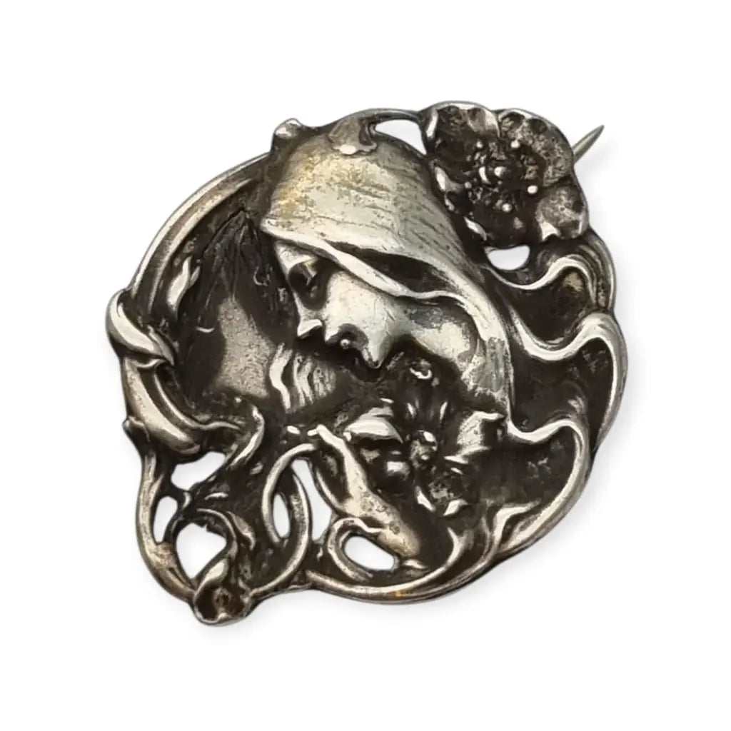 Broche Art Nouveau con mujer y flores en relieve diseño de líneas sinuosas