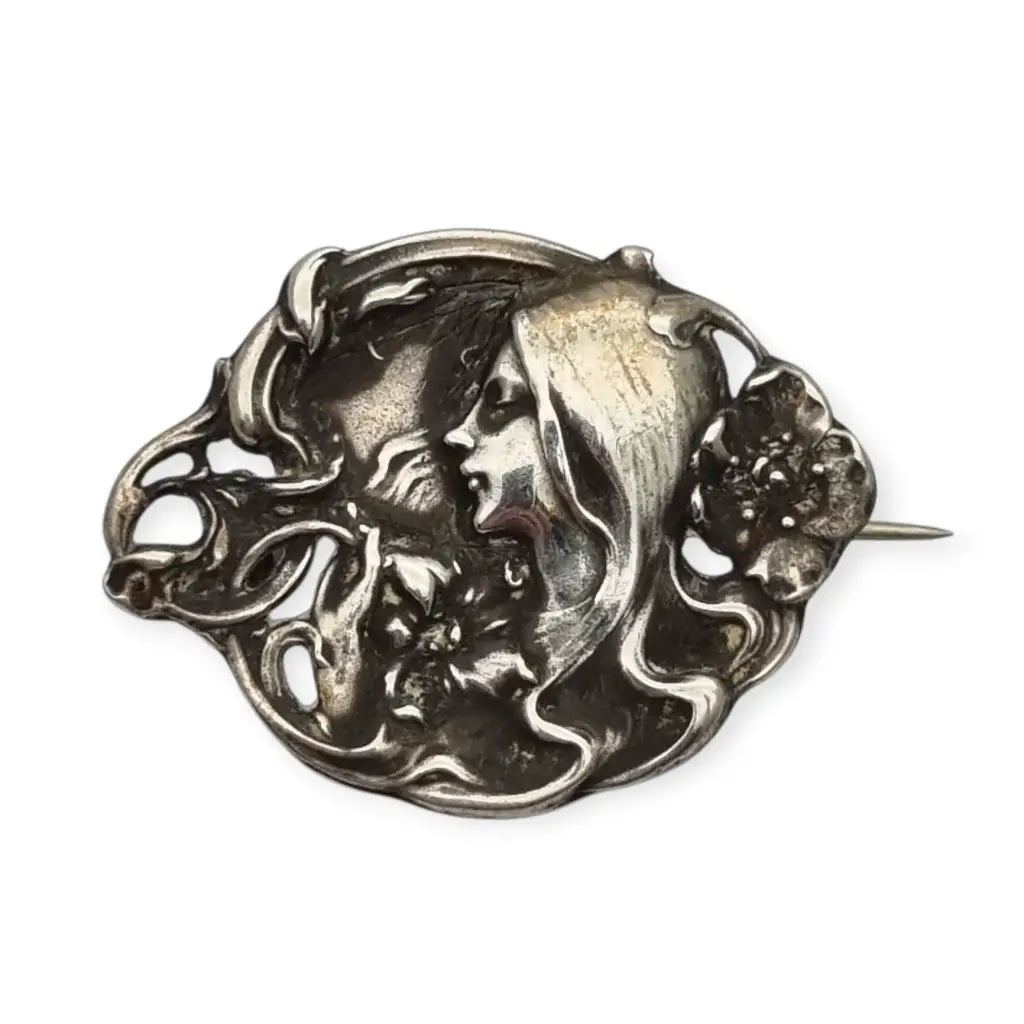 Broche Art Nouveau con mujer y flores en relieve diseño de líneas sinuosas