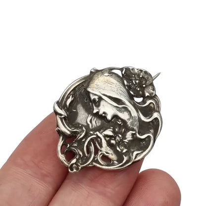 Broche Art Nouveau con mujer y flores en relieve diseño de líneas sinuosas