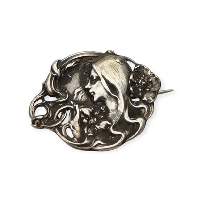 Broche Art Nouveau con mujer y flores en relieve diseño de líneas sinuosas
