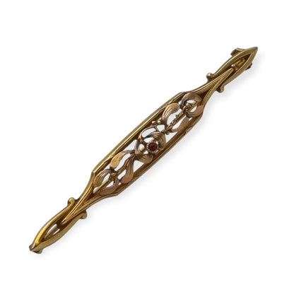 Broche Art Nouveau de Oria en oro laminado con flor calada y cristal rojo Circa