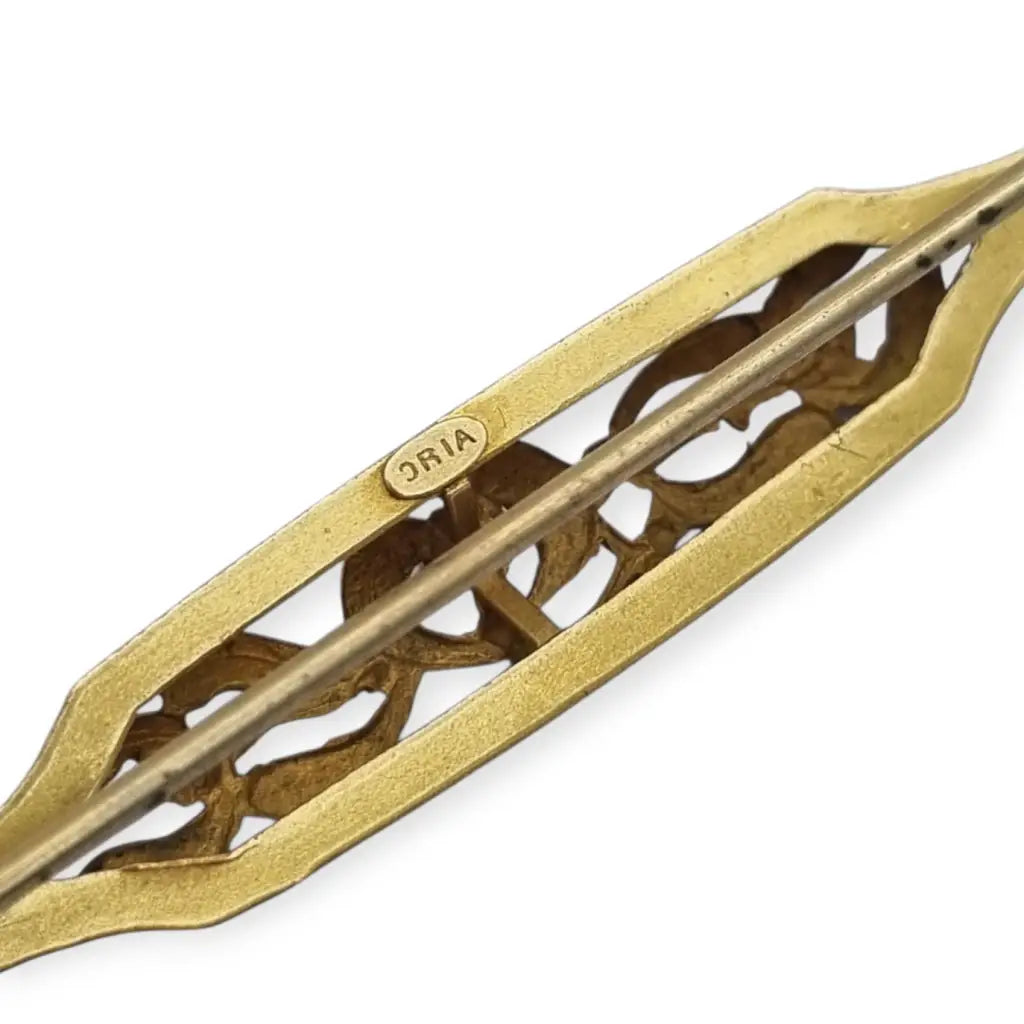 Broche Art Nouveau de Oria en oro laminado con flor calada y cristal rojo Circa