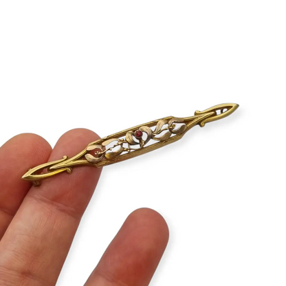 Broche Art Nouveau de Oria en oro laminado con flor calada y cristal rojo Circa