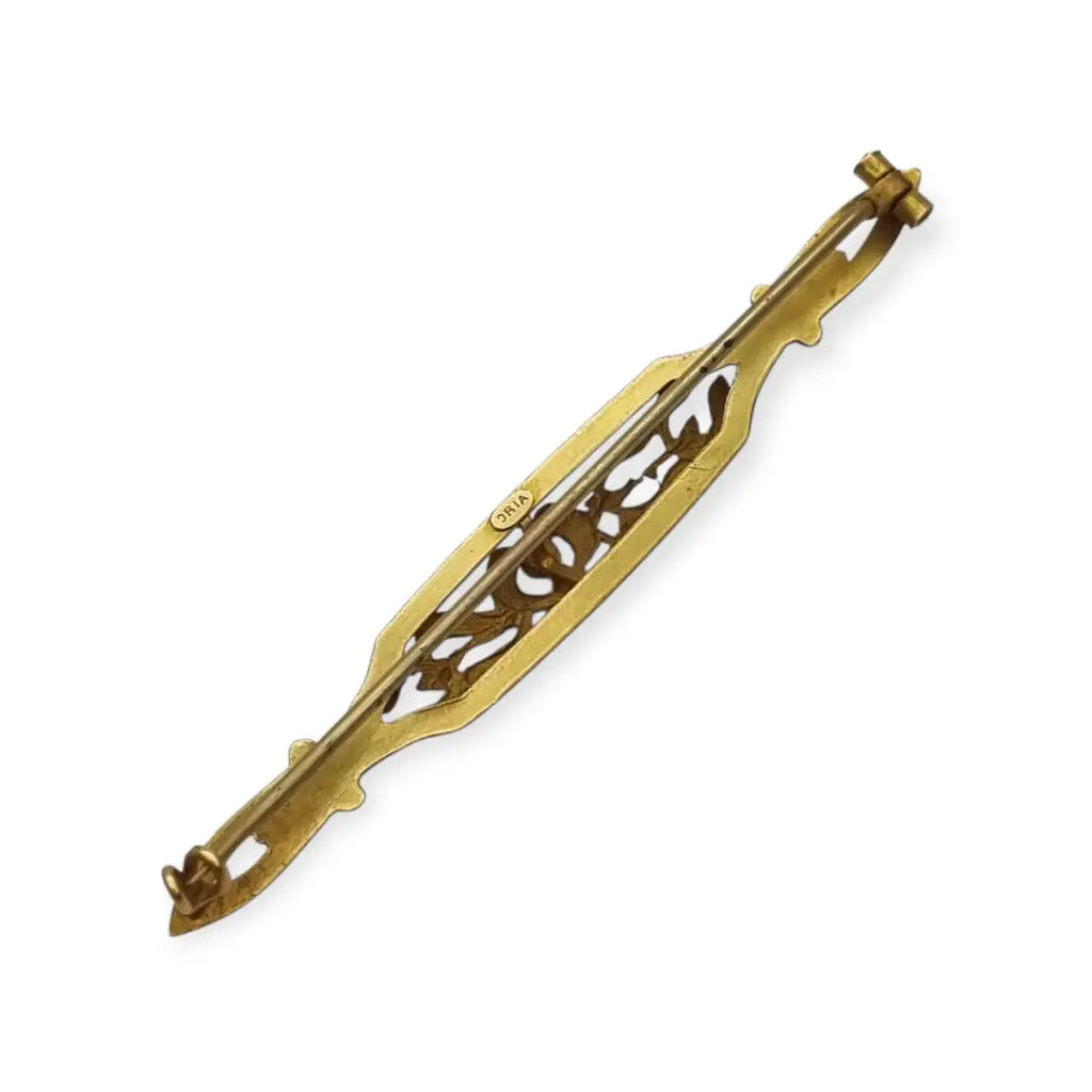 Broche Art Nouveau de Oria en oro laminado con flor calada y cristal rojo Circa