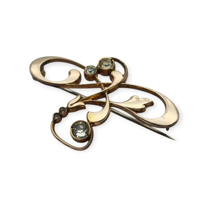 Broche Belle Époque de metal dorado con cristales y diseño floral curvilíneo