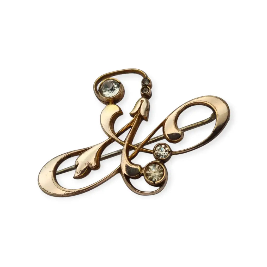 Broche Belle Époque de metal dorado con cristales y diseño floral curvilíneo