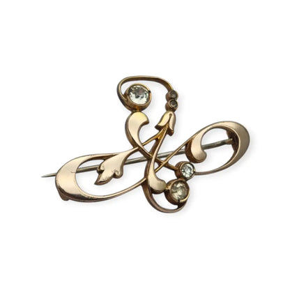 Broche Belle Époque de metal dorado con cristales y diseño floral curvilíneo