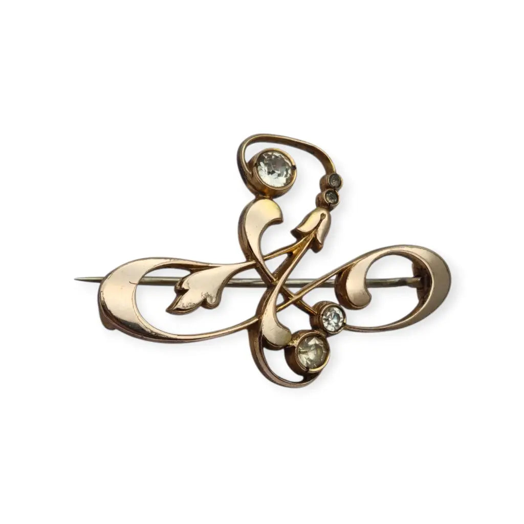 Broche Belle Époque de metal dorado con cristales y diseño floral curvilíneo