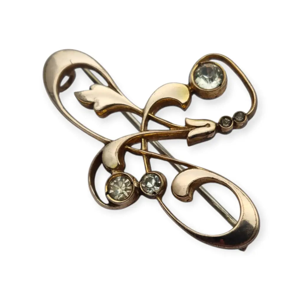 Broche Belle Époque de metal dorado con cristales y diseño floral curvilíneo