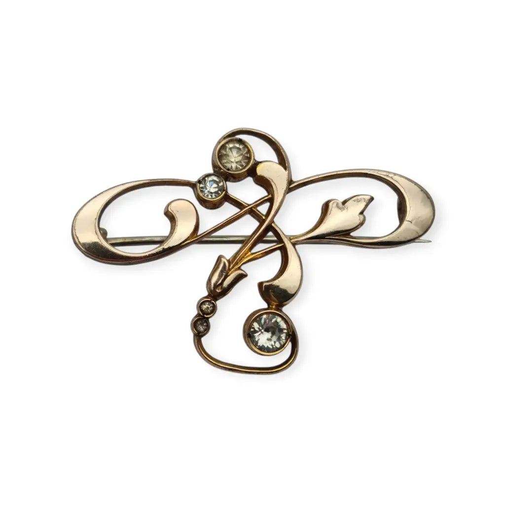 Broche Belle Époque de metal dorado con cristales y diseño floral curvilíneo