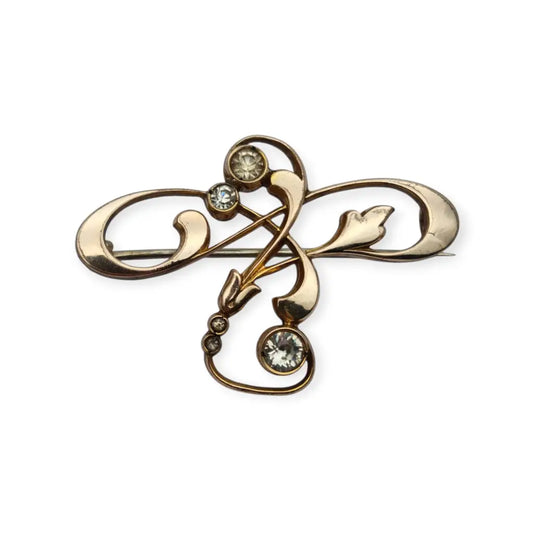 Broche Belle Époque de metal dorado con cristales y diseño floral curvilíneo