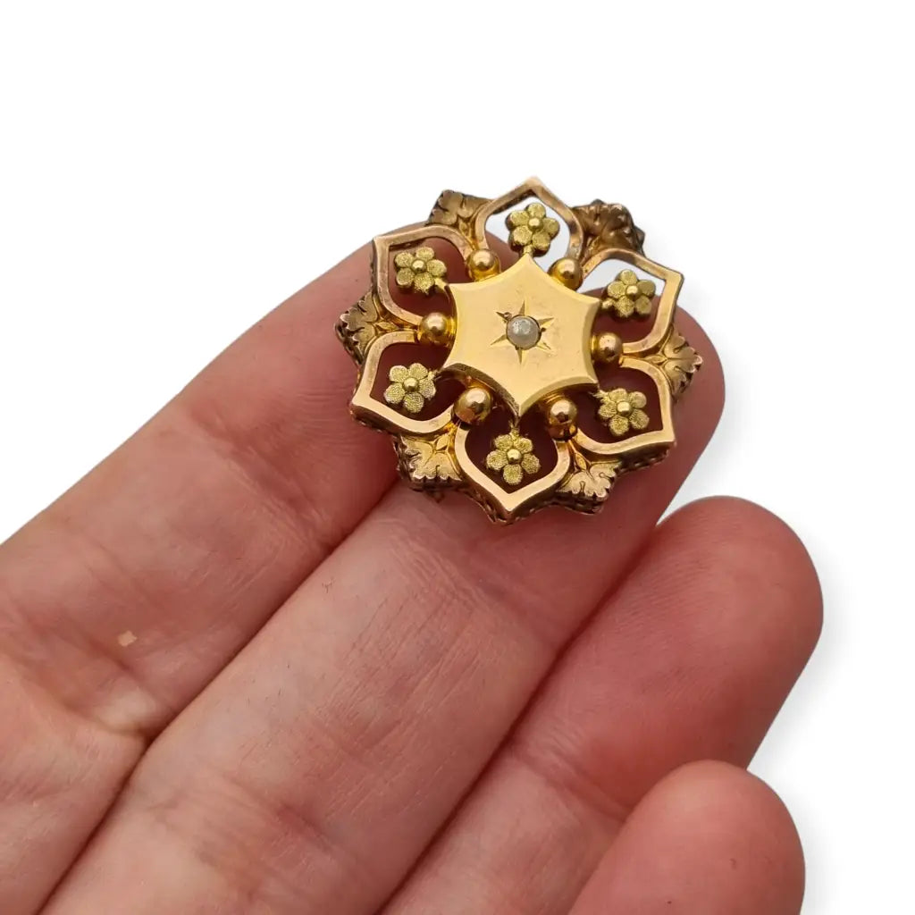 Broche francés vintage de oro FIX con diseño floral calado y una perla central