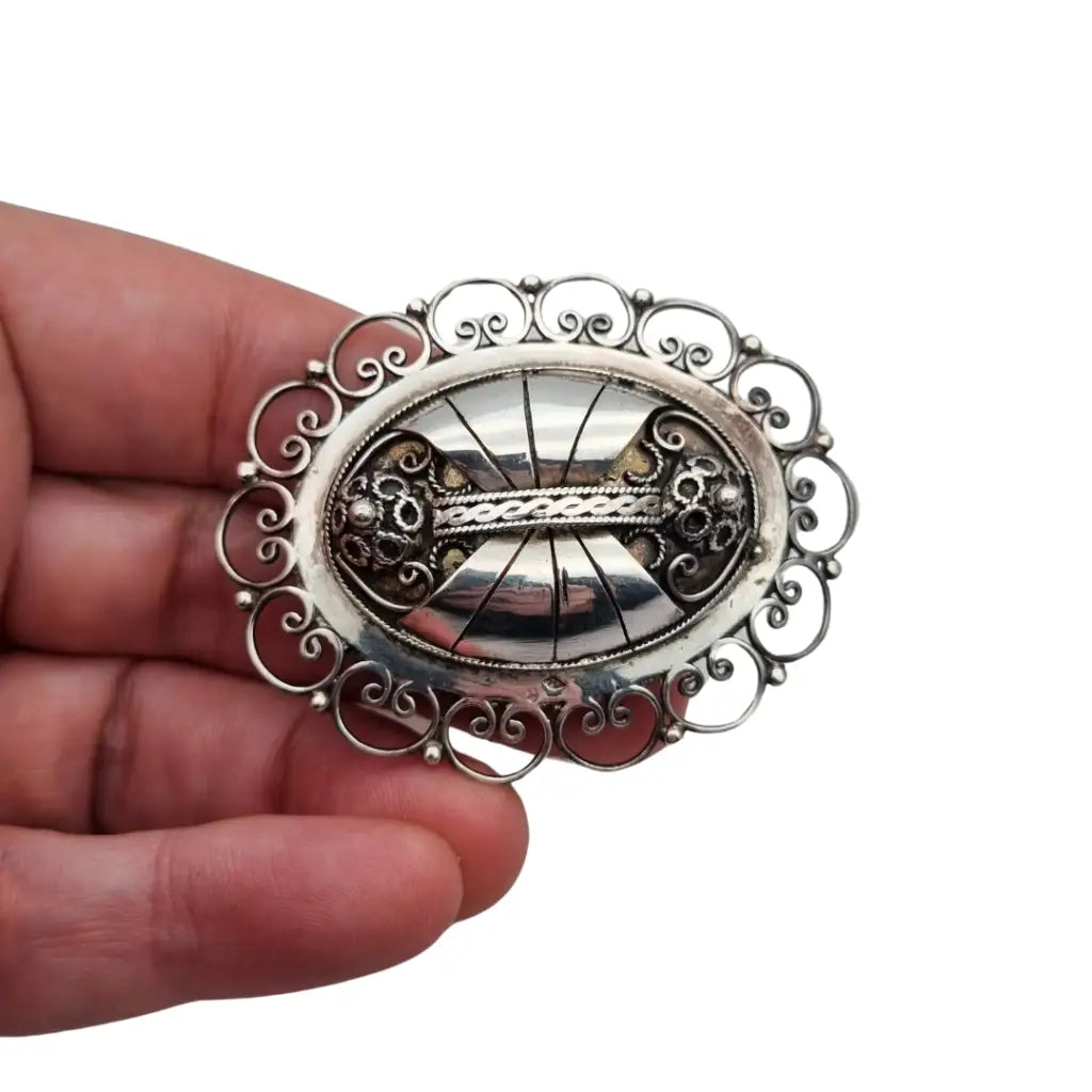 Broche ovalado de plata con filigrana popular detallada y diseño Art Nouveau.