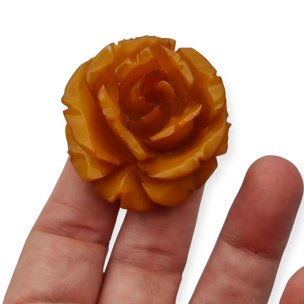 Broche redondo vintage de rosa tallado en baquelita ámbar circa 1930.