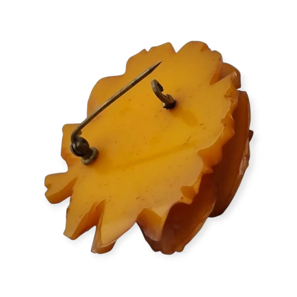 Broche redondo vintage de rosa tallado en baquelita ámbar circa 1930.