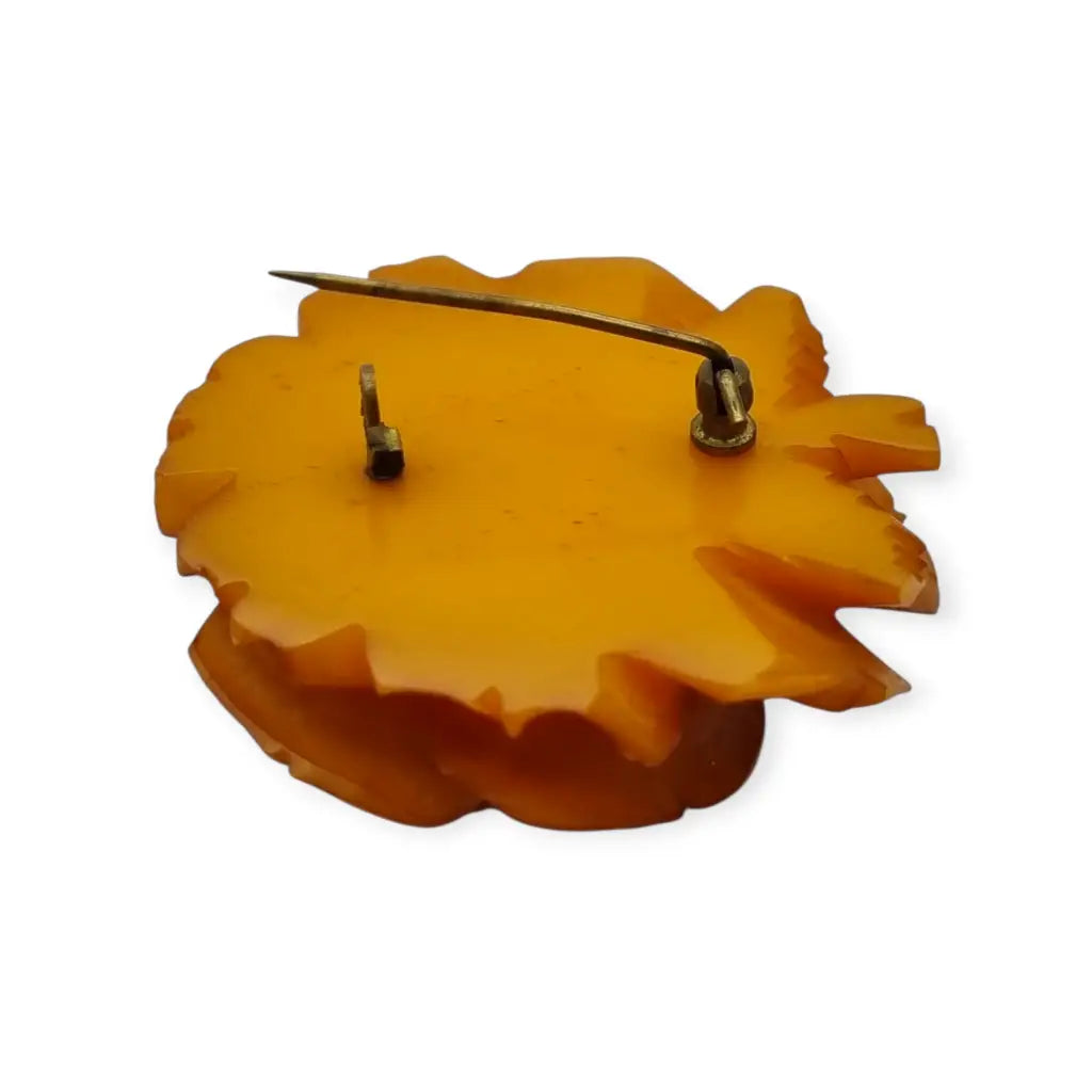 Broche redondo vintage de rosa tallado en baquelita ámbar circa 1930.