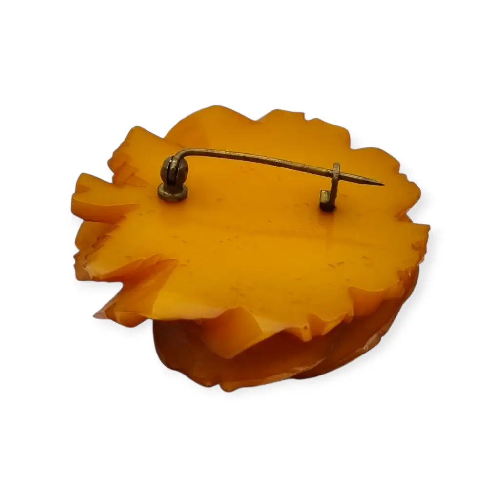 Broche redondo vintage de rosa tallado en baquelita ámbar circa 1930.