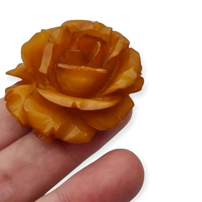 Broche redondo vintage de rosa tallado en baquelita ámbar circa 1930.