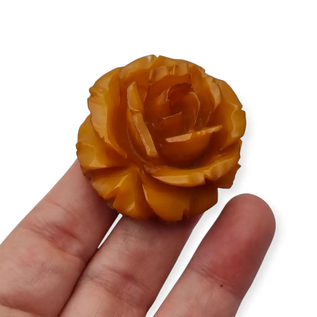 Broche redondo vintage de rosa tallado en baquelita ámbar circa 1930.