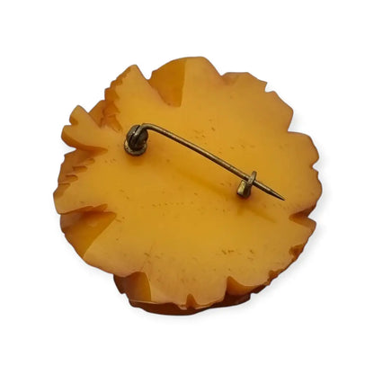 Broche redondo vintage de rosa tallado en baquelita ámbar circa 1930.