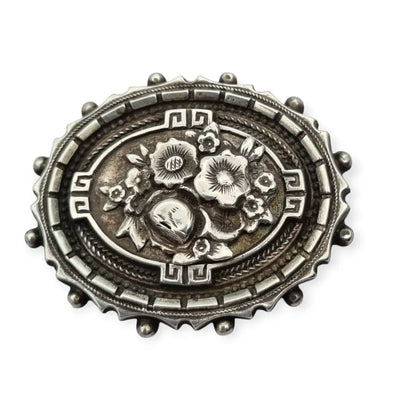 Broche relicario victoriano en plata de ley con flores relieve. Circa 1910.