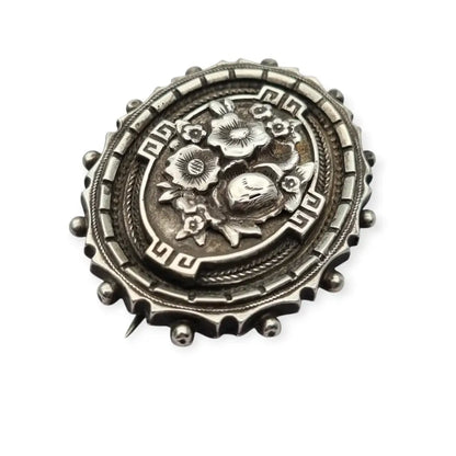 Broche relicario victoriano en plata de ley con flores relieve. Circa 1910.