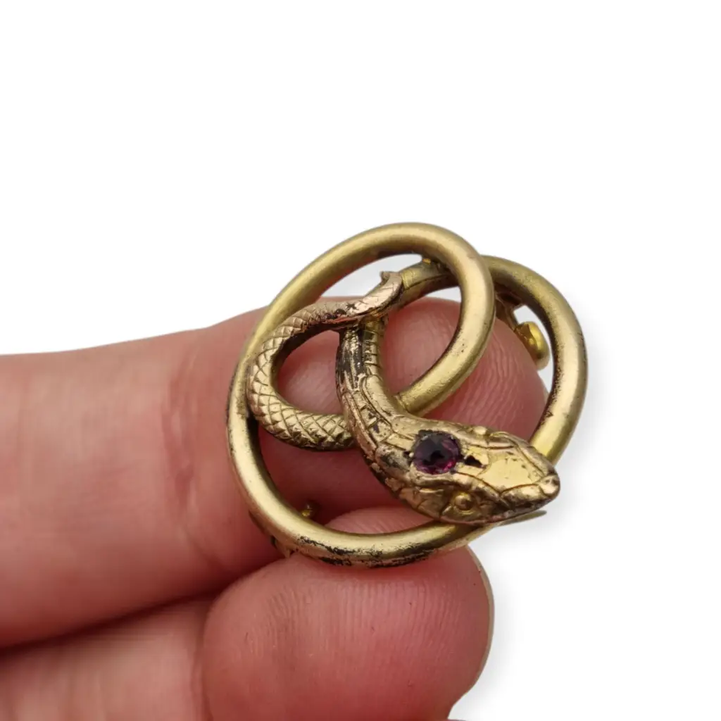 Broche victoriano antiguo en metal dorado con serpiente entrelazada y ojo