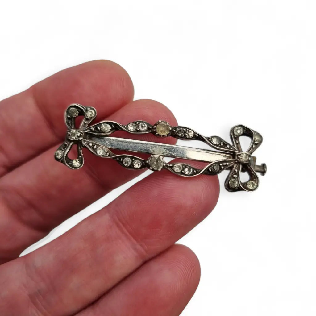 Broche art nouveau de plata con lazos y pedrería blanca para mujer.