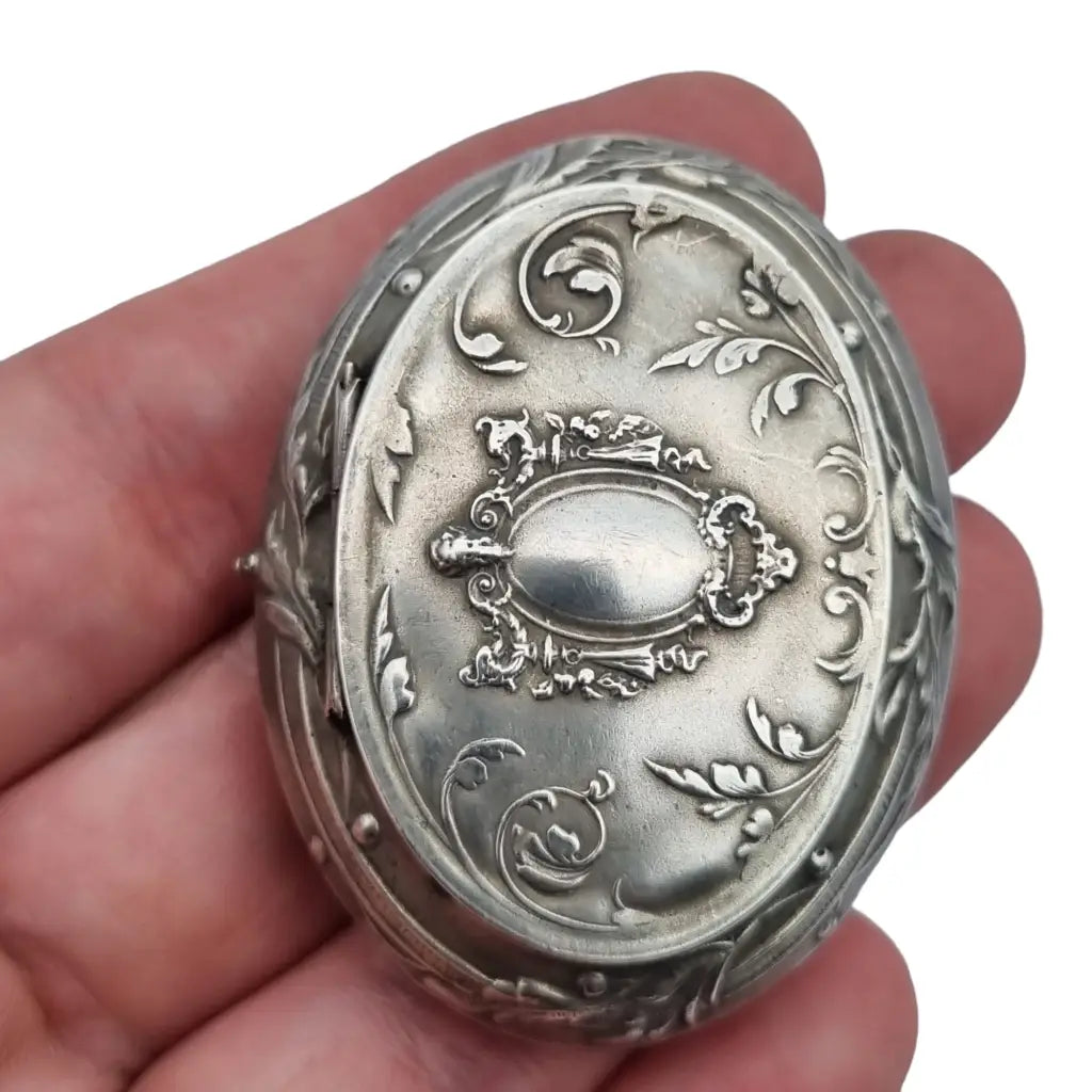 Caja de plata antigua modernista con decoración floral y espejo interior.