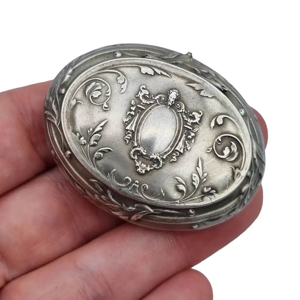 Caja de plata antigua modernista con decoración floral y espejo interior.