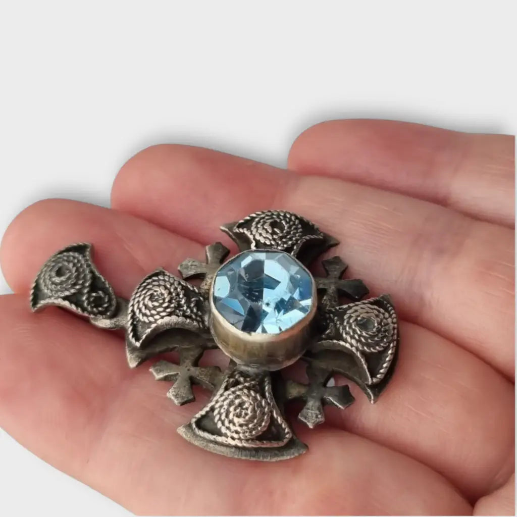 Colgante cruz maltesa de metal plateado con piedra azul decoración