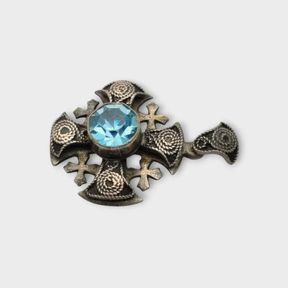 Colgante cruz maltesa de metal plateado con piedra azul decoración