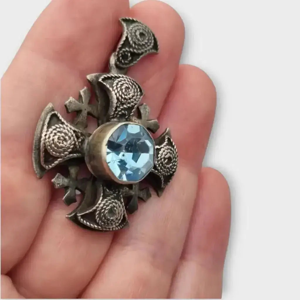 Colgante cruz maltesa de metal plateado con piedra azul decoración