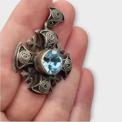 Colgante cruz maltesa de metal plateado con piedra azul decoración