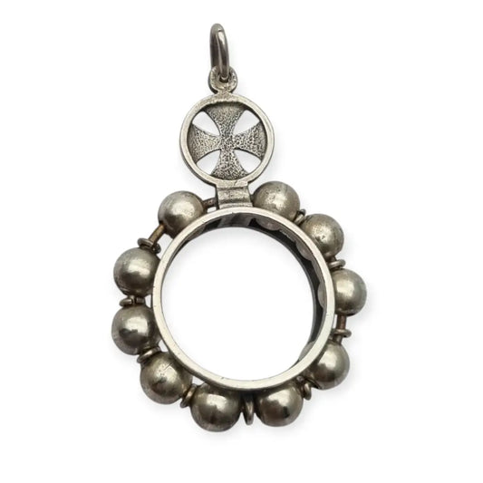Colgante relicario redondo en plata con cruz calada y orla de cuentas.