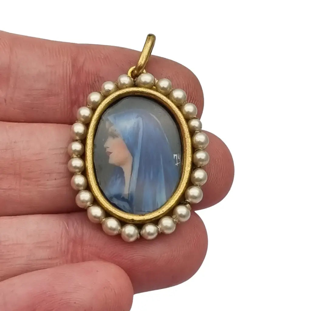 Colgante religioso con una Virgen azul pintada y firmada marco dorado