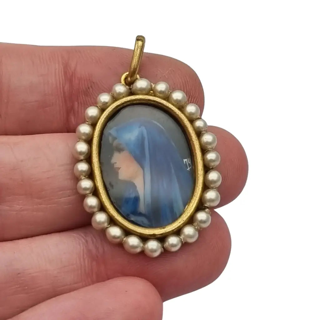 Colgante religioso con una Virgen azul pintada y firmada marco dorado