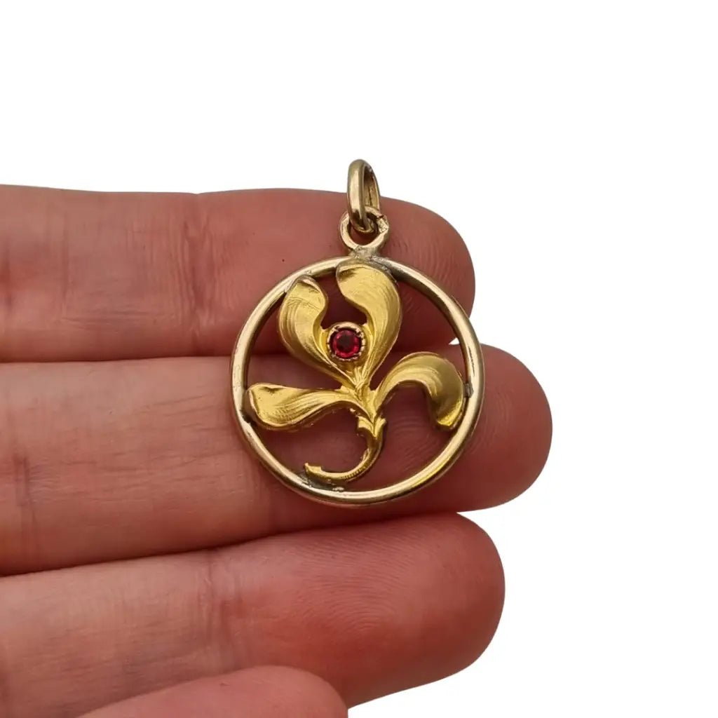 Colgante vintage art nouveau dorado con flor en círculo y piedra roja diseño