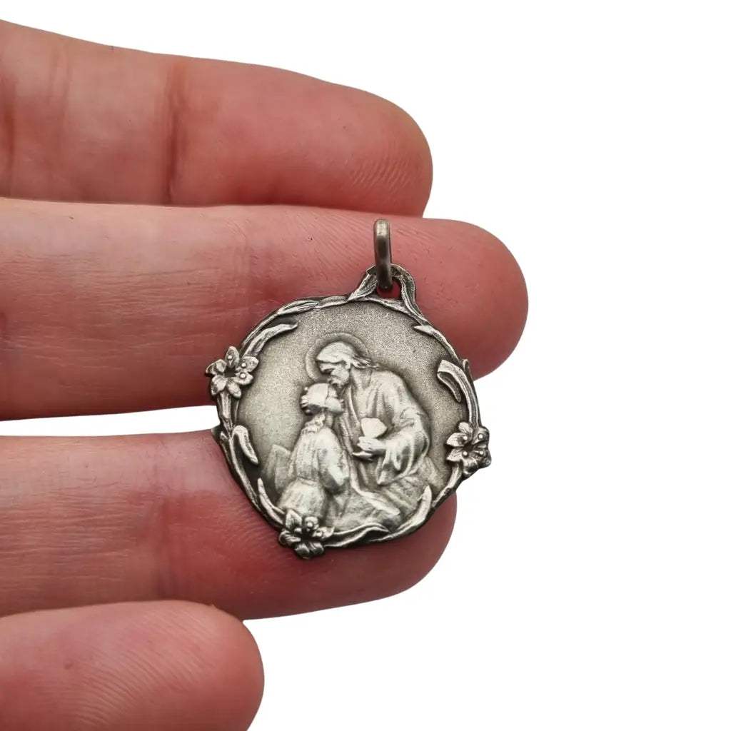 Medalla antigua comunión en plata Jesús y niña arrodillada detalles florales