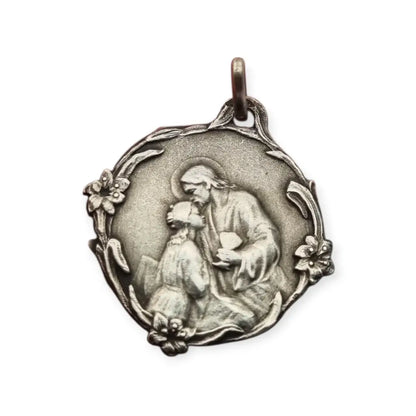 Medalla antigua comunión en plata Jesús y niña arrodillada detalles florales