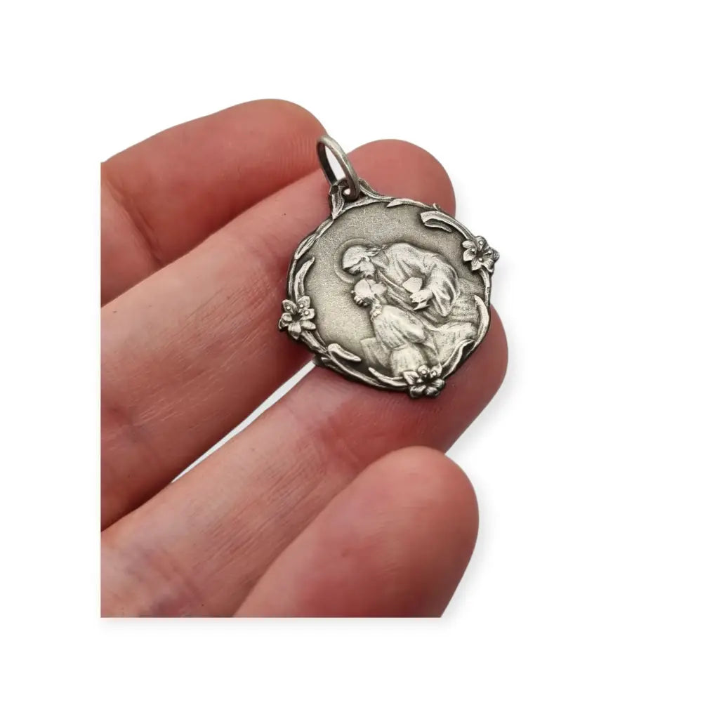 Medalla antigua comunión en plata Jesús y niña arrodillada detalles florales