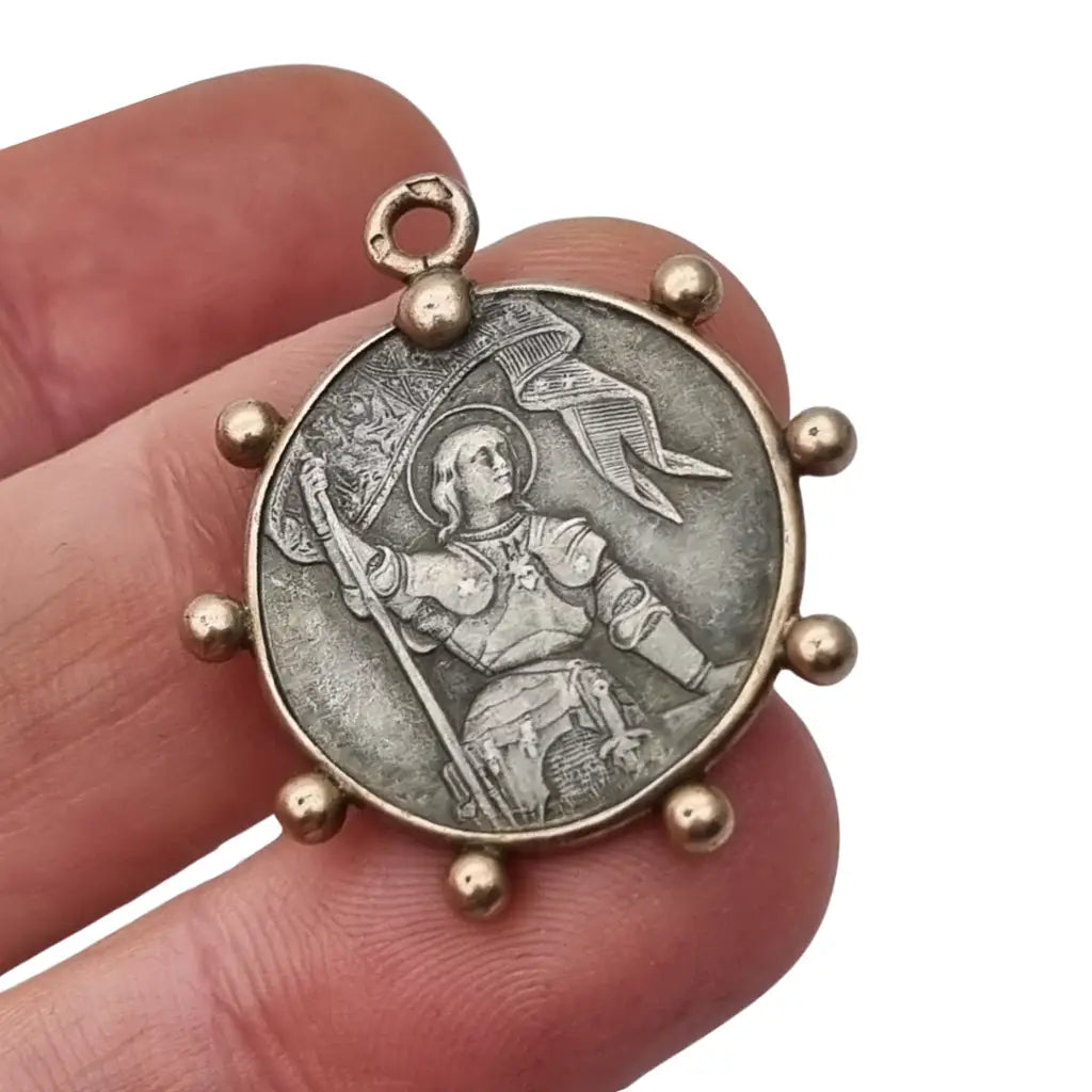 Medalla de plata Juana Arco Francia símbolo religioso y patriótico.