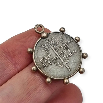 Medalla de plata Juana Arco Francia símbolo religioso y patriótico.