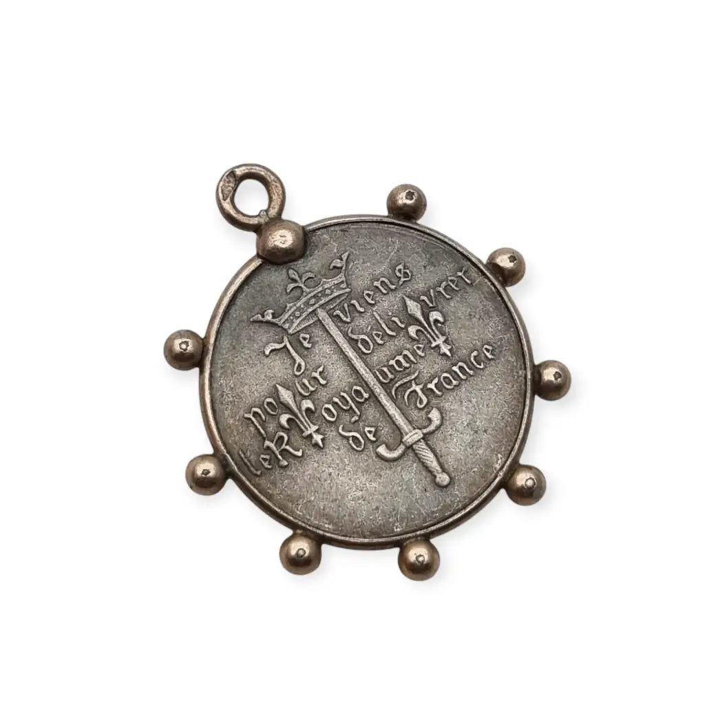 Medalla de plata Juana Arco Francia símbolo religioso y patriótico.