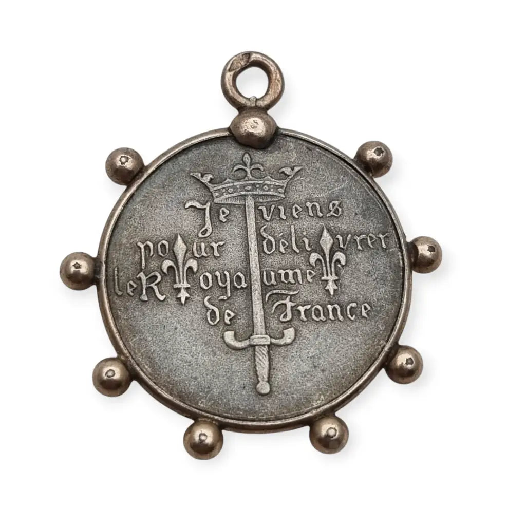 Medalla de plata Juana Arco Francia símbolo religioso y patriótico.