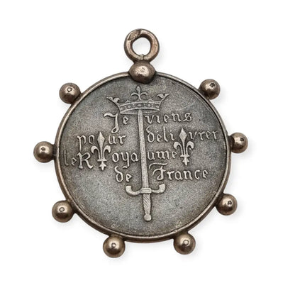 Medalla de plata Juana Arco Francia símbolo religioso y patriótico.