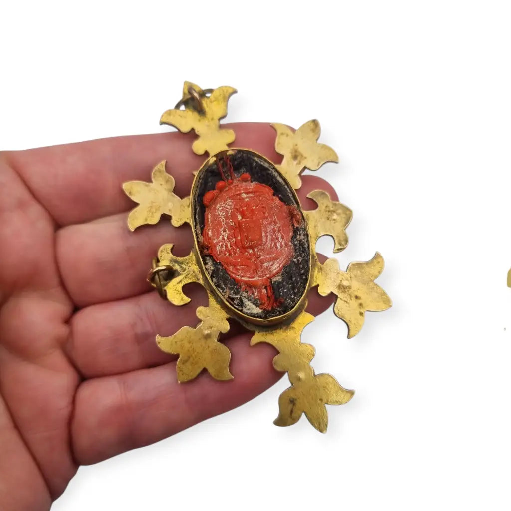 Relicario antiguo colgante con cinco reliquias selladas en metal dorado y gemas